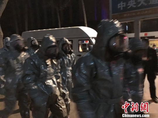 十几名身着防护服的人员头戴面具进入事发地。　胡健 摄